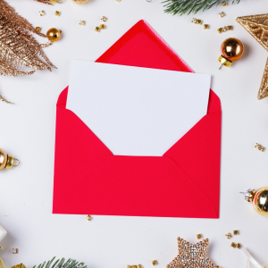 A blank card in an envelope with holiday decor