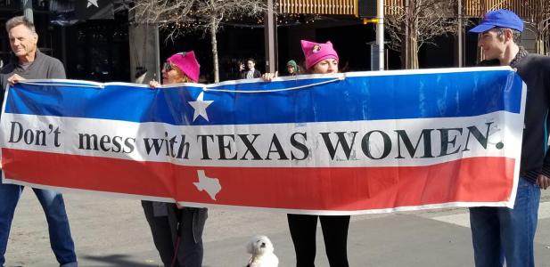 People marching with a poster reading: don't mess with Texas women