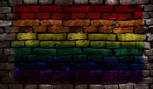 A rainbow flag painted on a brick wall